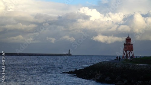 Pier and lighthouse in the ocean in South Shields, UK on a windy cold winters day. photo