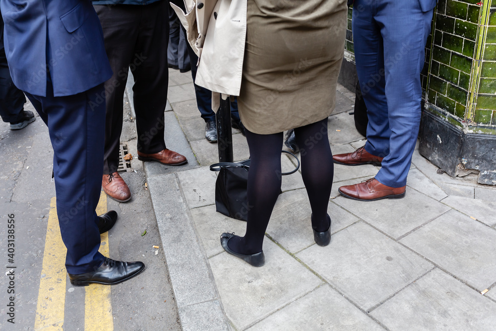 business men and woman standing together on a sidewalk business men and woman standing together on a sidewalk
