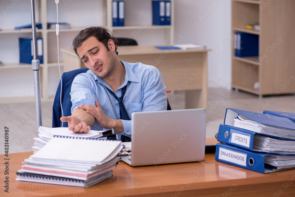 Young male employee suffering at workplace Young male employee suffering at workplace