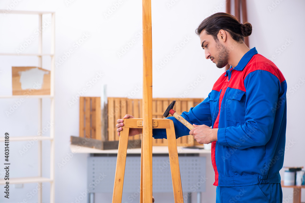 Young male contractor working in workshop Young male contractor working in workshop