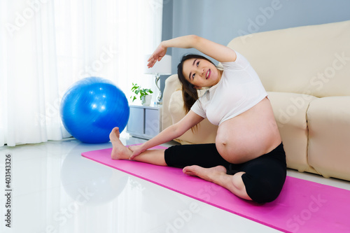 pregnant woman doing yoga exercise in living room at home © geargodz