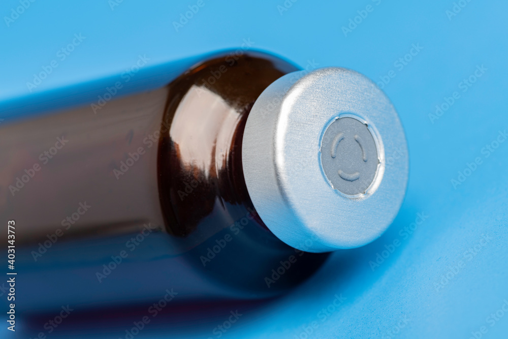 Macro Image Of Amber Vaccine Vial In Blue Background Macro Image Of Amber Vaccine Vial In Blue Background
