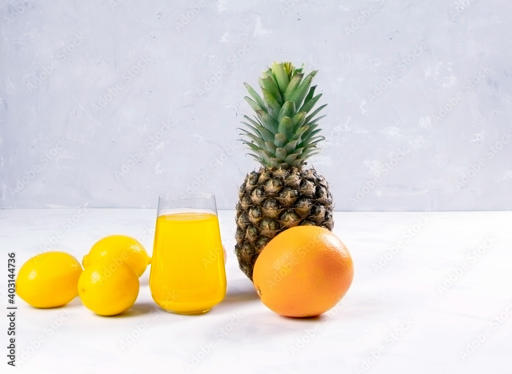Fresh fruits and juice on a white background. Helthy food. Vegaterian. Copy space. Place for text. An orange and pineapple.Lemons Fresh fruits and juice on a white background. Helthy food. Vegaterian. Copy space. Place for text. An orange and pineapple.Lemons