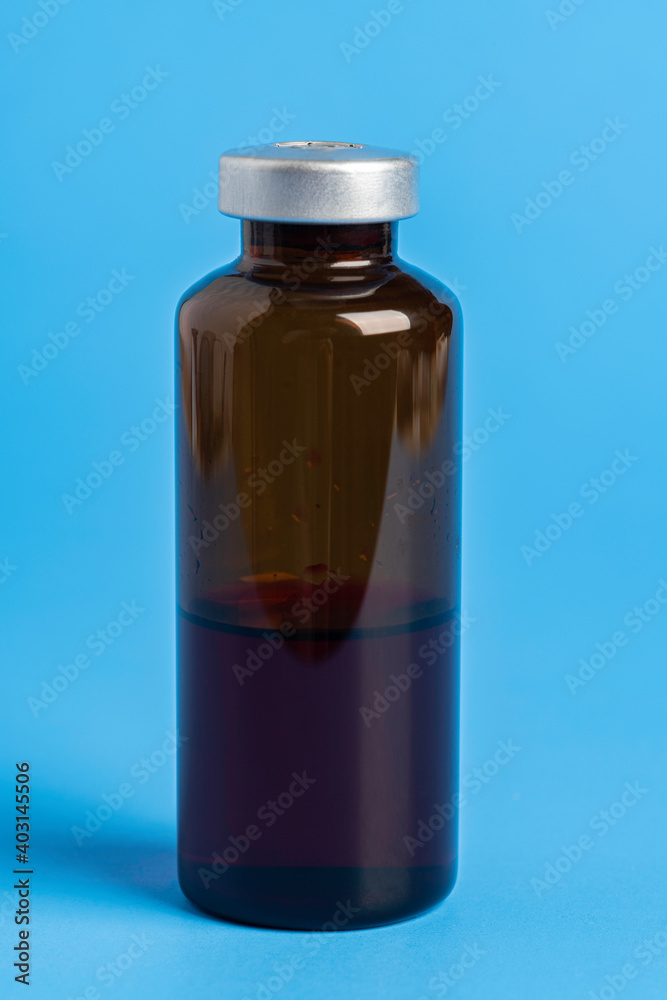 Macro Image Of Amber Vaccine Vial In Blue Background Macro Image Of Amber Vaccine Vial In Blue Background