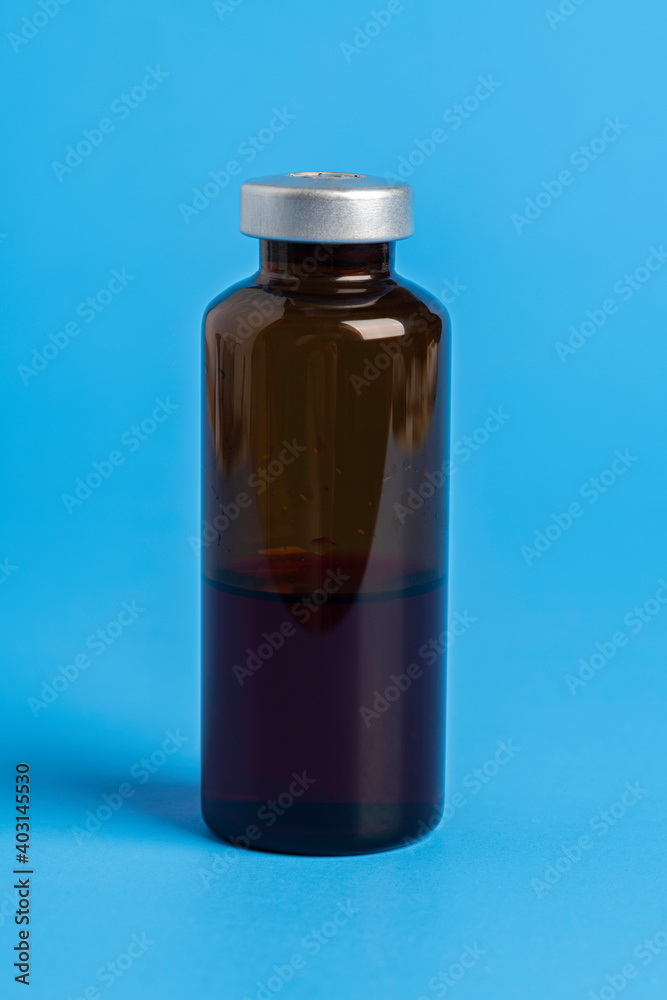 Macro Image Of Amber Vaccine Vial In Blue Background Macro Image Of Amber Vaccine Vial In Blue Background
