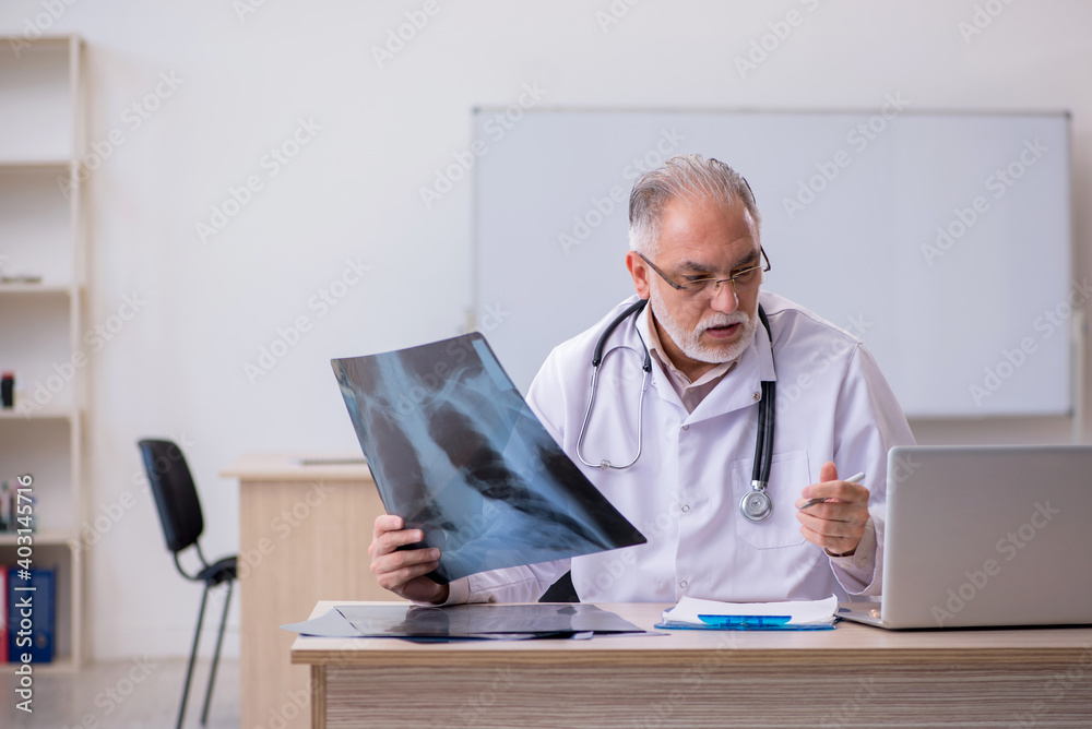Old male doctor radiologist working in the clinic Old male doctor radiologist working in the clinic