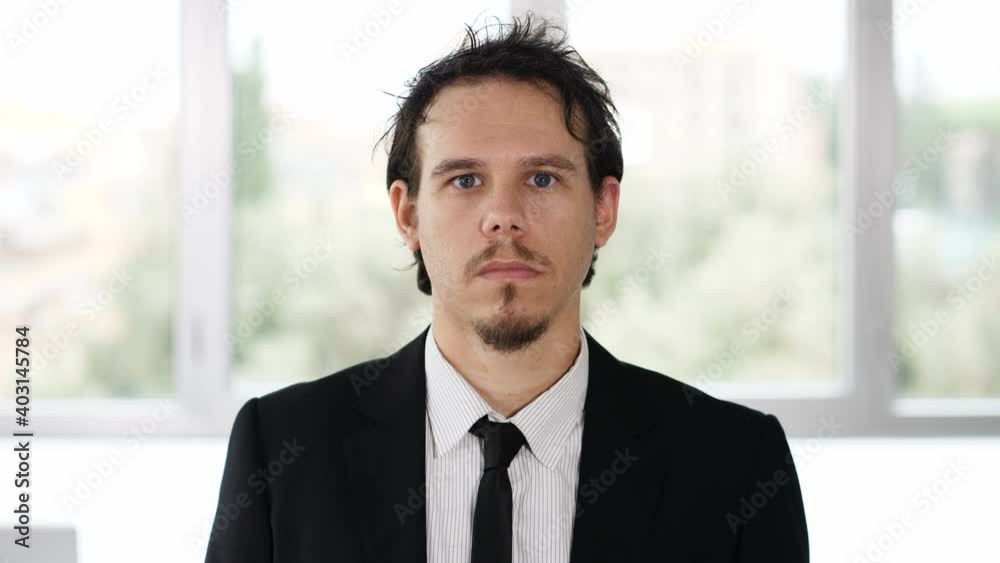 work, business - young focused manager stares serious at camera work, business - young focused manager stares serious at camera
