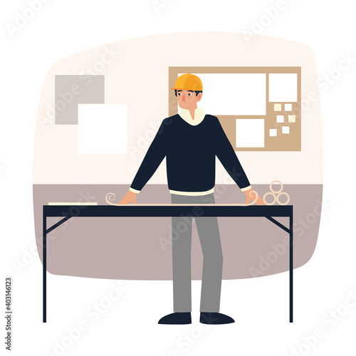 young male architect with blueprint on table in the office