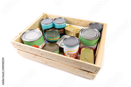 Foto a collection of generic label food tins or cans in a wooden crate isolated on wh