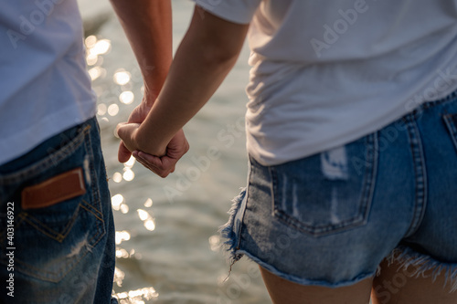 Young couple standing hand in hand on the beach. Couple on a summer vacation at the beach.Summer in love,Valentine day concept.