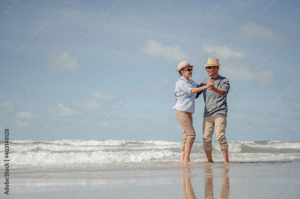 Senior couple dancing on the beach at sunny day. Plan life insurance with the concept of happy retirement. Senior couple dancing on the beach at sunny day. Plan life insurance with the concept of happy retirement.