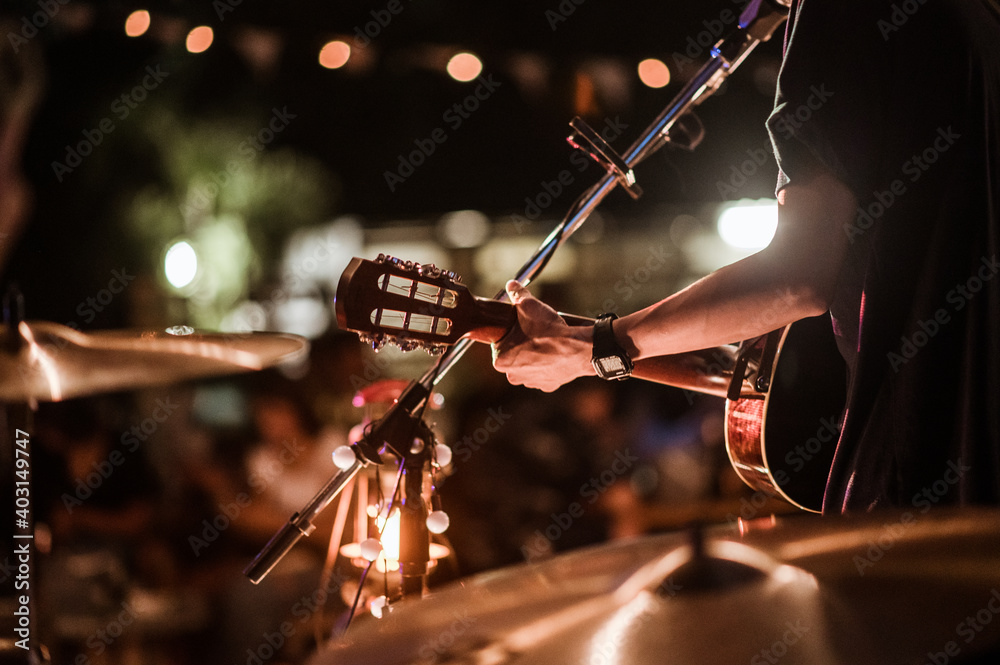 The musicians were playing rock music on stage, there was an audience full of people watching the concert. Concert,mini concert and music festivals. - obrazy, fototapety, plakaty 