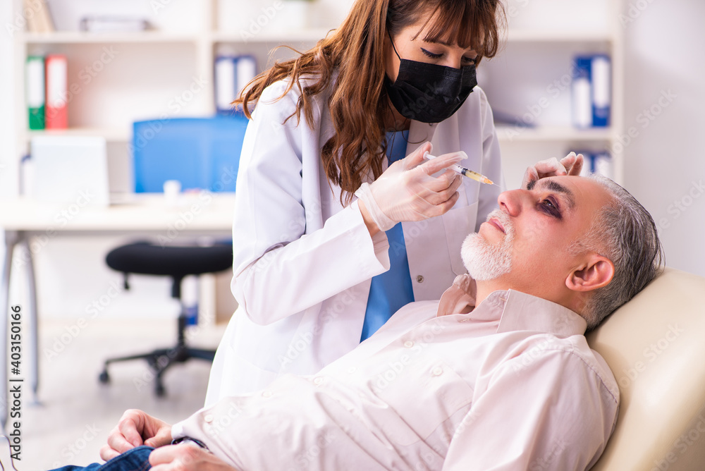 Obraz premium Old man visiting young female doctor for plastic surgery
