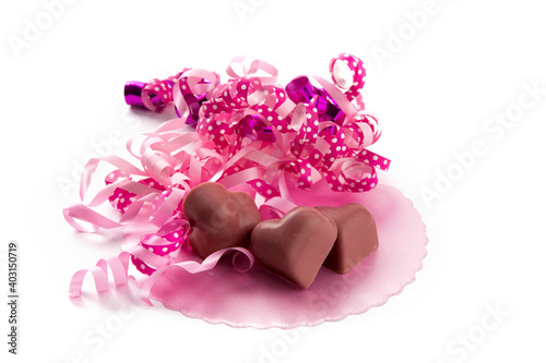 pink valentines heart shaped chocolates and a pink ribbon isolated on white