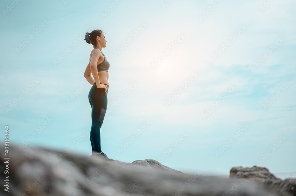 Asian woman stands to breathe in natural air on the beach. Healthy,exercise fitness and lifestyle concept.
