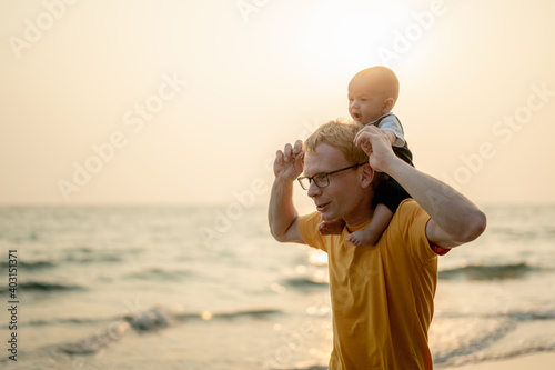 Father and son playing on the beach at the day time. People having fun on the beach. Holiday Family on the beach in summer, Travel, vacation and lifestyle concept.