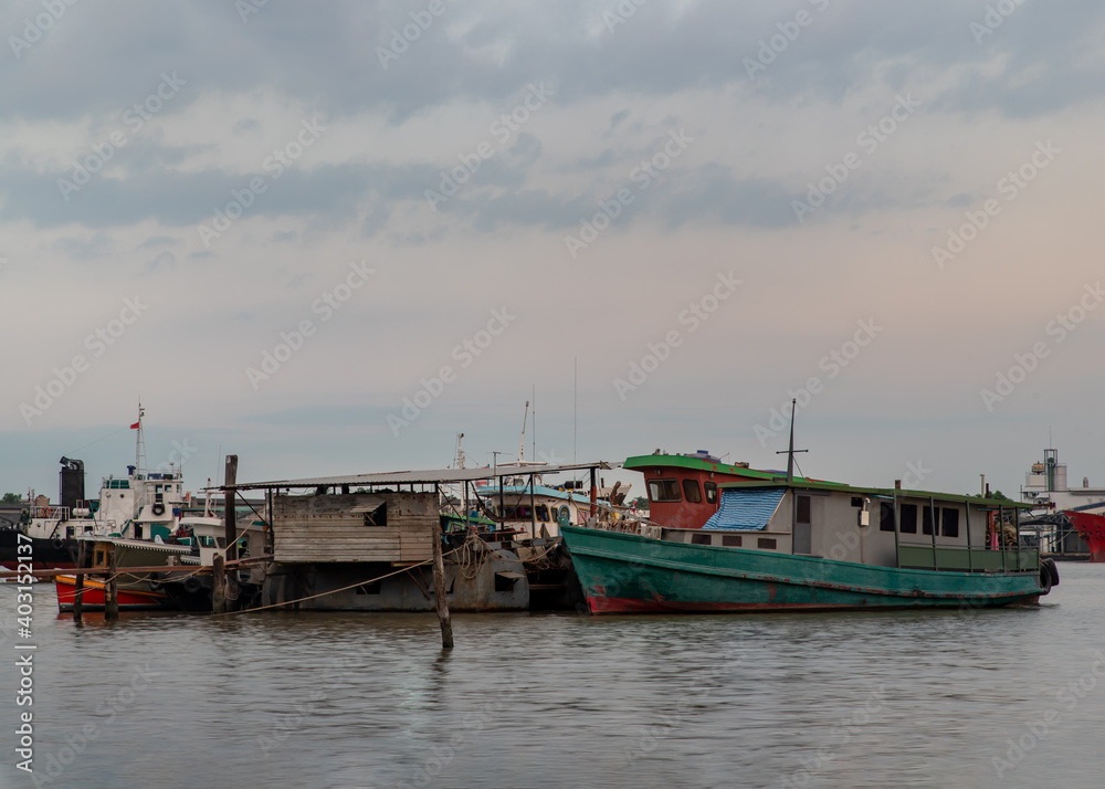 Bangkok, Thailand - 04 Jan 2021 : A small cargo ship parked in front of the small pier at Chao Phraya river. Selective focus.