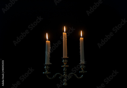 Bilde på lerret burning candles in candelabra on a black background