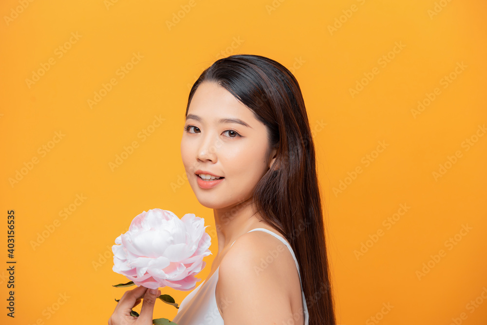 woman holding peony bouquet over yellow