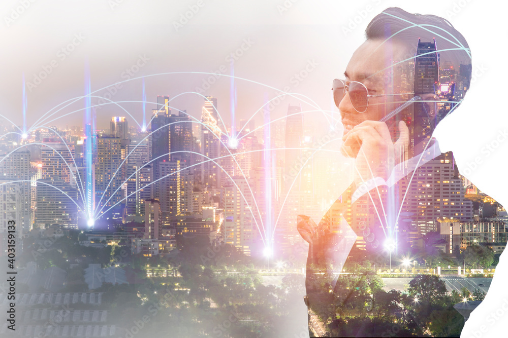 Double exposure image of businessman are calling smartphone with  wireless communication network over the city.