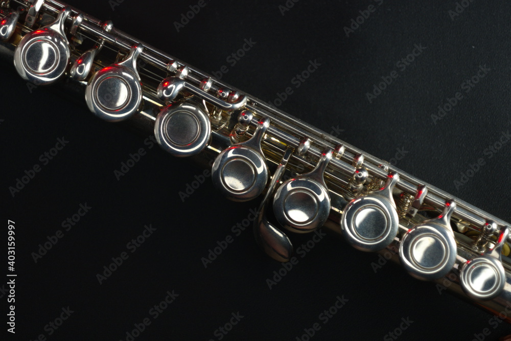 Fototapeta premium Concert flute (part) on dark background with red accent lights