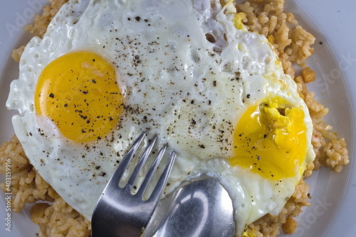 A dish of fried rice (nasi goreng) with two fried eggs with pepper