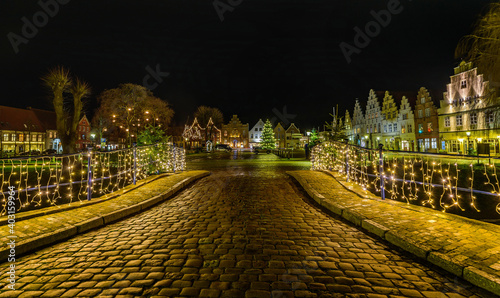 View of festive lighting and Christmas romantic atmosphere in Friedrichstadt at night. Nighttime view of Friedrichstadt  at Christmas, New Year time, Schleswig-Holstein, Germany, Europe. photo