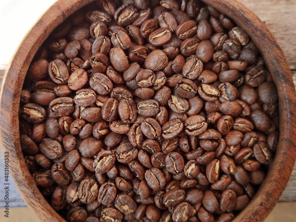 Close up of coffee beans in wooden bowl for background