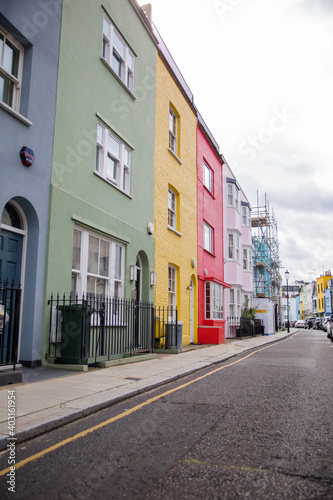 Row of colorful British houses with handrails and plants © Christian