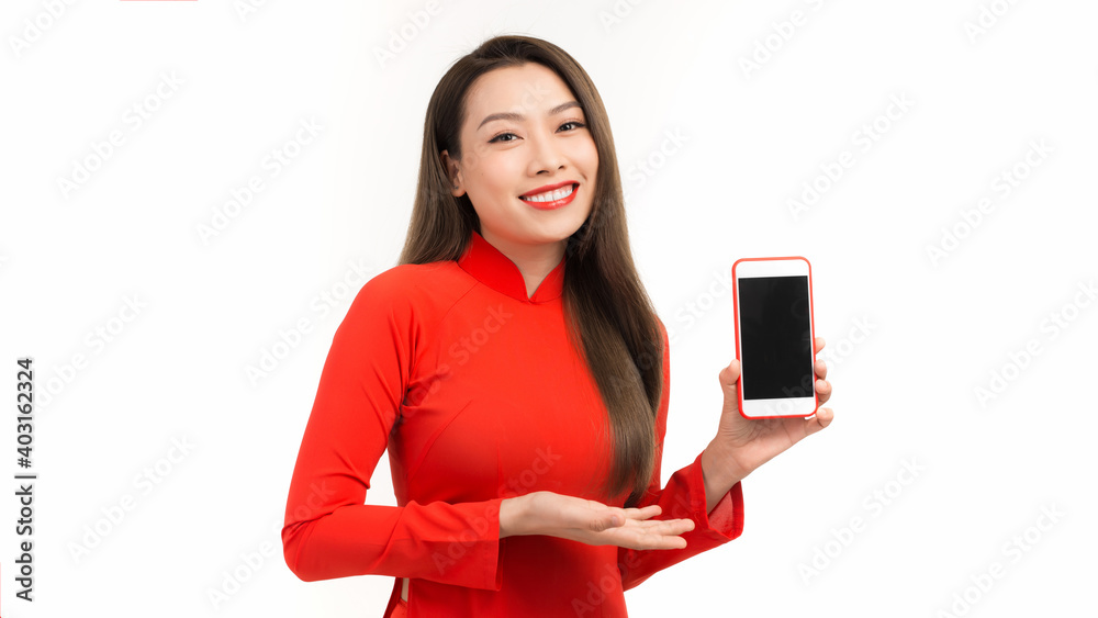 Young beautiful Asian woman pointing at black empty space on smart phone background can use for advertising or product presenting concept Young beautiful Asian woman pointing at black empty space on smart phone background can use for advertising or product presenting concept