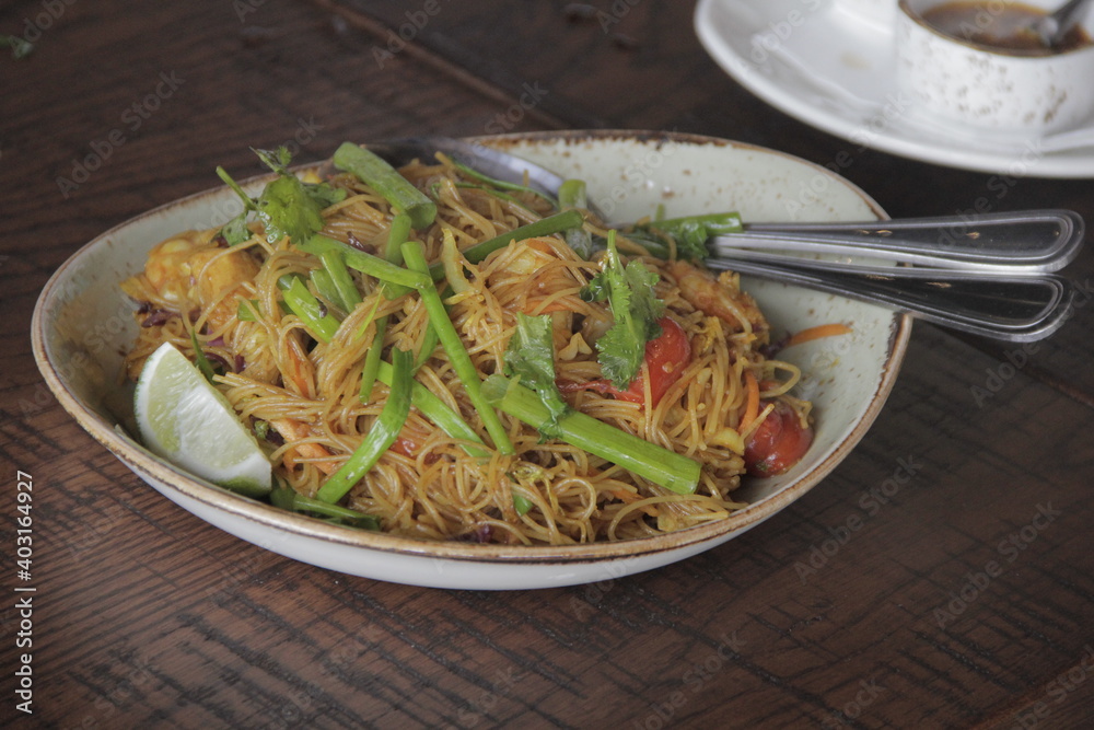 Singapore Street Noodles
Delgados fideos de arroz combinados con pollo, camarones, tomates y vegetales frescos, salteados en una salsa de curry