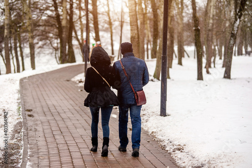 A guy and a girl walking in winter Park 