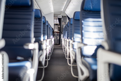 Empty dark blue passenger airplane seats in the cabin.
