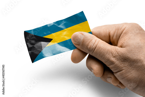 Hand holding a card with a national flag the Bahamas