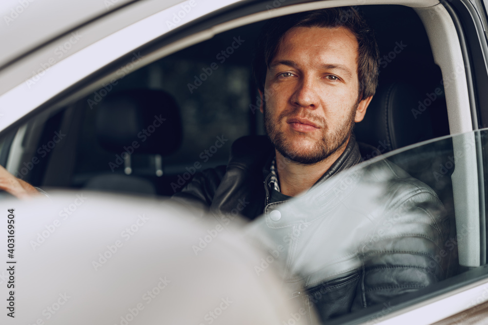 Confident young man sitting in a car Confident young man sitting in a car