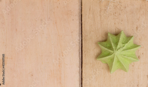 Green, sweet, crispy meringue on a wooden background.