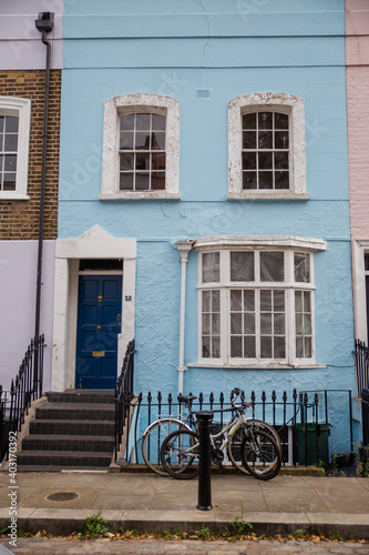 Blue British house with handrail and a bicycle parked outside © Christian