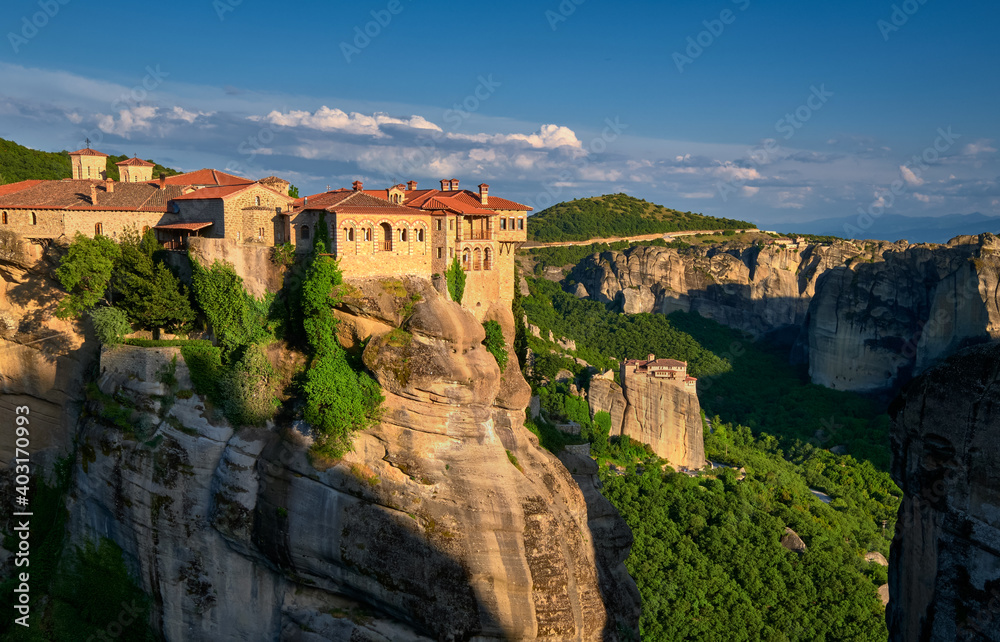 Cliff top Varlaam monastery, evening sun, Meteora, Greece, typical landscape of rocks. Moni Agias Varvaras Roussanou nunnery. UNESCO World Heritage
