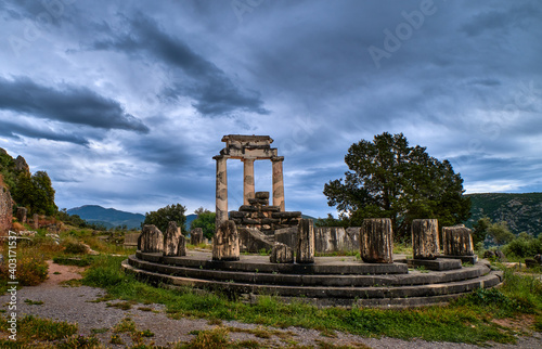 Ruins of Tholos of ancient Greek goddess Athena Pronaia in Delphi, Greece. Circle of parts and restored Doric columns. UNESCO World heritage site