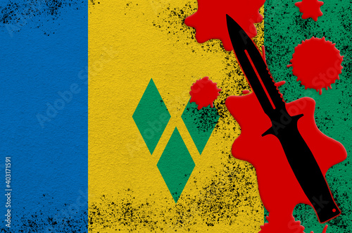 Saint Vincent and the Grenadines flag and black tactical knife in red blood. Concept for terror attack or military operations with lethal outcome photo