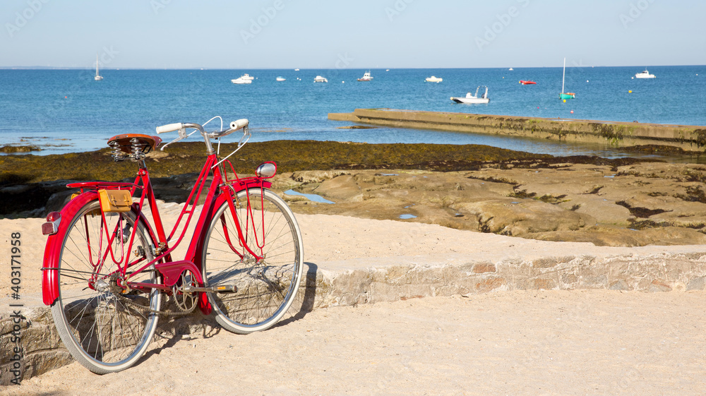 Bord de mer en France, vieux vélo rouge à la plage.