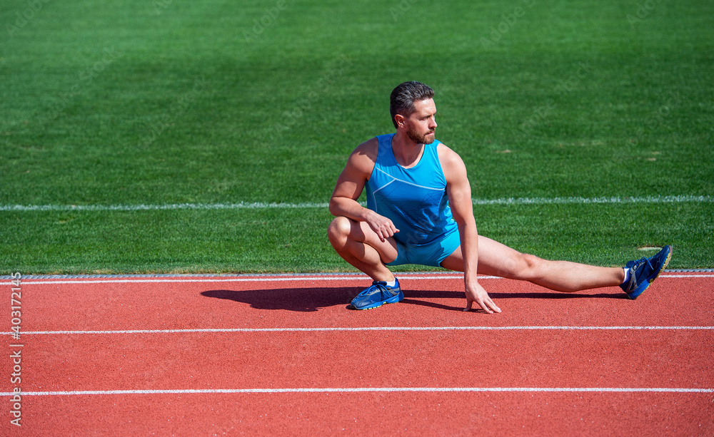 Obraz premium mature man stretching his legs before a stadium workout, stretch