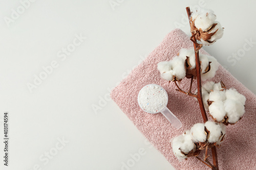 Scoop with washing powder, cotton and towel on white background