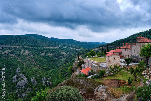 View of clifftop monastery buildings and terrace of Holy Trinity or Agia Triada on rocks of Meteora hills, Greece, UNESCO World Heritage