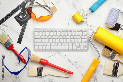 Painting tools and computer keyboard on light background