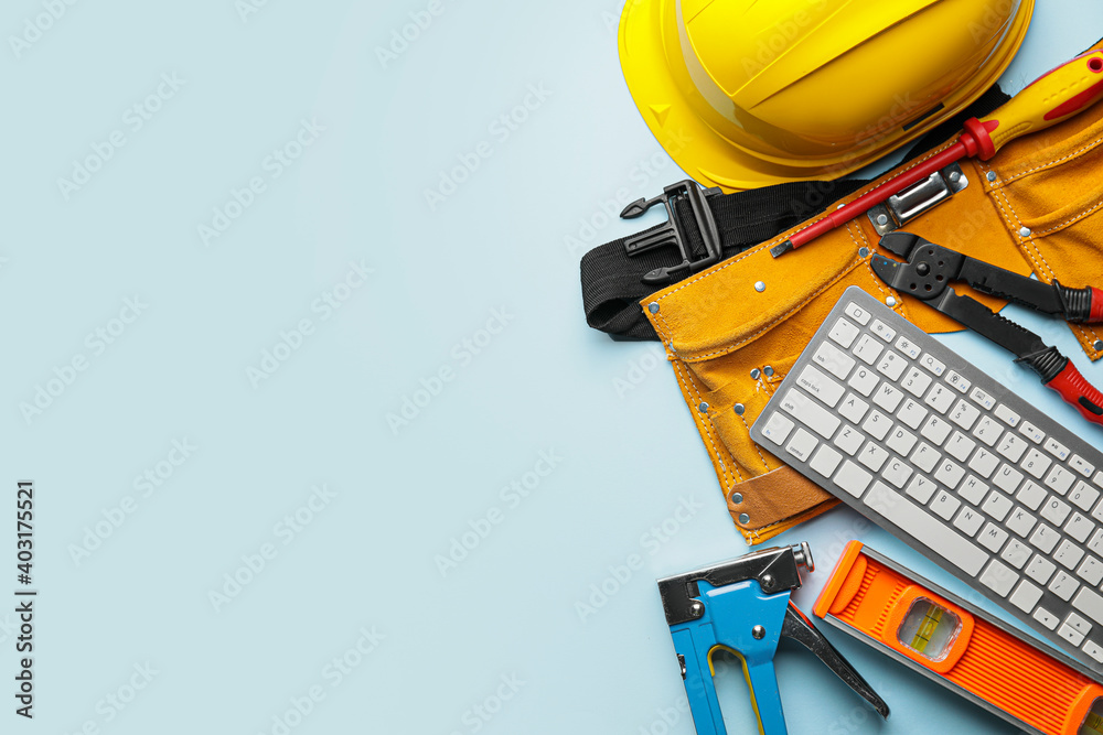 Construction tools and computer keyboard on color background - obrazy, fototapety, plakaty 