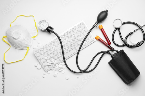 Computer keyboard and medical supplies on white background