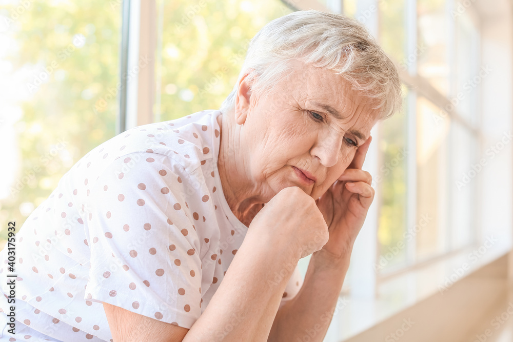 Stressed senior woman suffering from headache at home Stressed senior woman suffering from headache at home