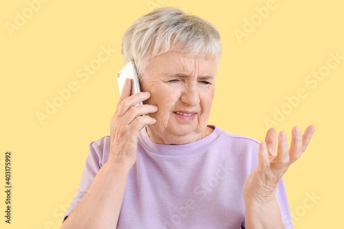 Stressed senior woman talki...