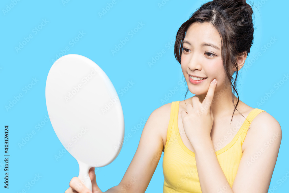 鏡でお肌をチェックする女性